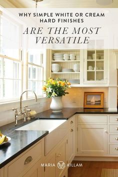 a kitchen with white cabinets and black counter tops