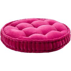 a pink round dog bed sitting on top of a white floor