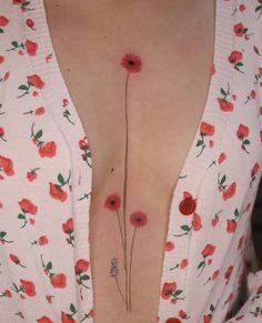 a woman's chest with red flowers on it and one flower in the middle