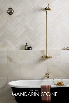 a bath tub sitting next to a shower head in a bathroom with white and black tile