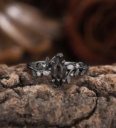 a black diamond ring sitting on top of a rock