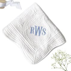 a white towel with the word rws on it next to a flower and ribbon