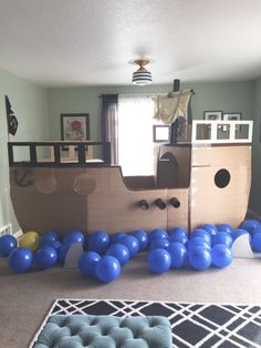 a room with blue balloons and a pirate ship on the wall in front of it