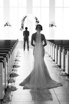 a bride and groom standing in front of pews