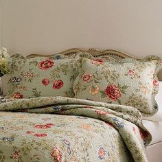 a bed with a floral comforter and pillows