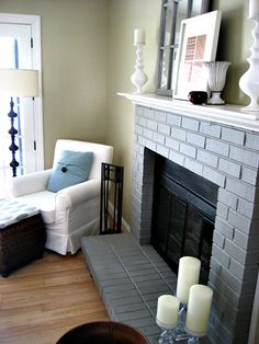 a living room filled with furniture and a fire place in front of a fireplace covered in candles