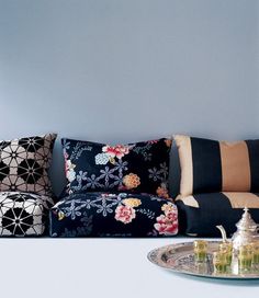 a living room filled with lots of furniture and pillows on top of a white table