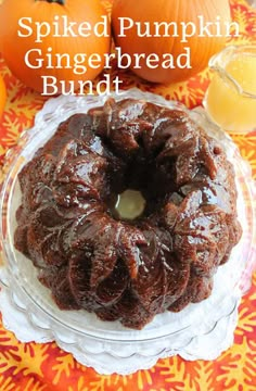 a bundt cake sitting on top of a glass plate next to some oranges