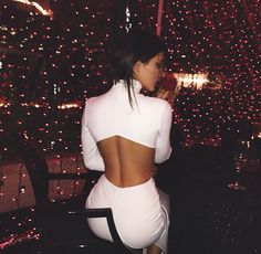 the back of a woman's white dress on her instagram page, with fireworks in the background