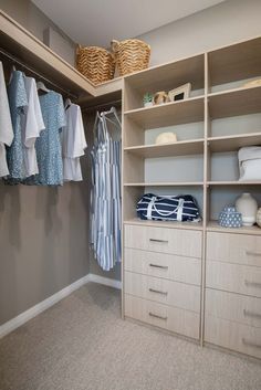 an organized closet with clothes hanging on shelves