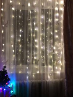 the curtains are covered with lights in front of a window