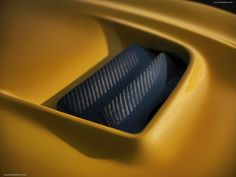 the interior of a yellow sports car with carbon fiber in it's center console