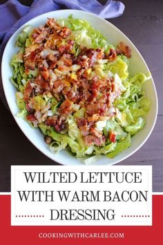 a white bowl filled with lettuce, bacon and dressing on top of a wooden table