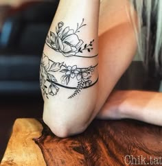 a woman's leg with flowers on it and a circle in the middle that reads,