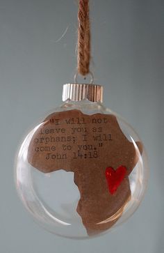 a glass ornament with a red heart in the shape of a africa map