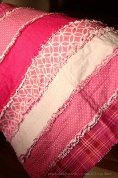 a pink and white striped pillow sitting on top of a wooden floor