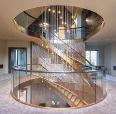 a spiral staircase with glass railing and chandelier