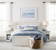 a bedroom with white furniture and blue bedding