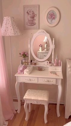 a white dressing table with a mirror and stool