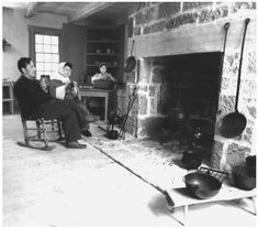 three people sitting in front of a fire place