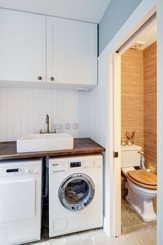 a washer and dryer in a bathroom with wooden counter tops on the floor