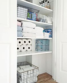 a white closet filled with lots of towels and toilet paper on top of shelving units