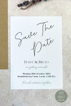 the save the date card is next to some flowers