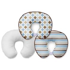 three neck pillows sitting next to each other on top of a white surface with brown and blue designs