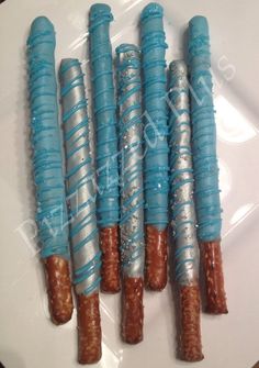 four blue and silver wrapped hot dogs on a white plate