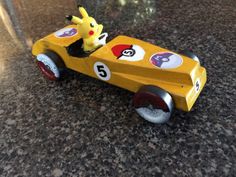 a yellow toy car with pikachu on the front and number five on the back