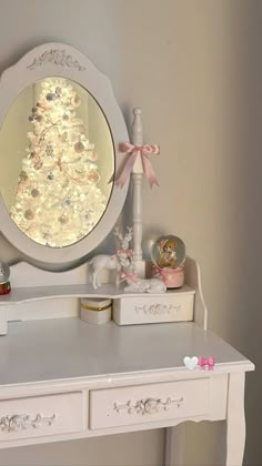 a white desk topped with a mirror and a christmas tree on it's side