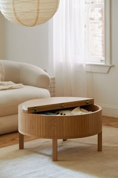 a living room with a round coffee table in the middle and a white couch behind it