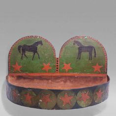 an old wooden bowl with horses painted on the sides and red stars around the rim