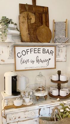 a coffee bar with cups and mugs sitting on top of an old white cabinet