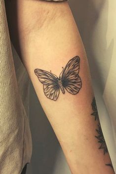 a woman's arm with a butterfly tattoo on the left side of her arm