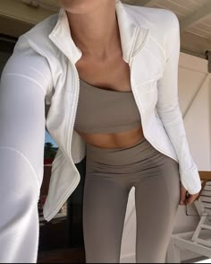 a woman in white jacket and grey leggings