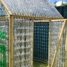 a building made out of plastic bottles in the grass