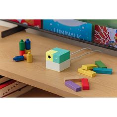 a wooden table topped with toys on top of it next to a book shelf filled with children's books