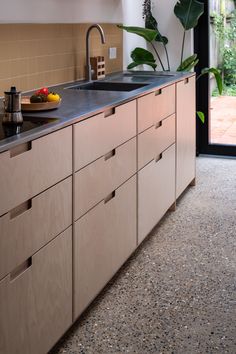 a modern kitchen with wooden cabinets and black counter tops is seen in this image from the outside