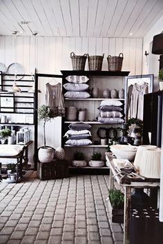 a room filled with lots of furniture and baskets on top of it's shelves