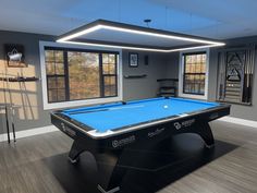 a room with a pool table and several windows