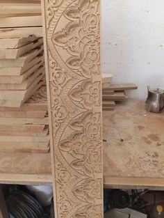 an intricately carved piece of wood sitting on top of a workbench in a workshop