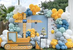 a construction themed birthday party with balloons and streamers in the shape of a bulldozer