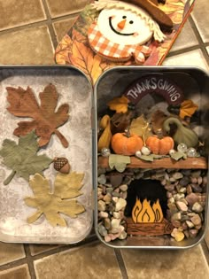 three tins filled with different types of fall decorations