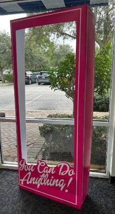 a pink mirror sitting on top of a window sill