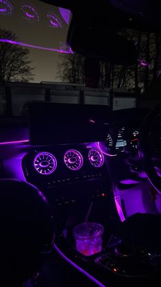 the interior of a car is lit up with purple lights