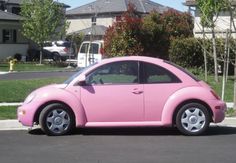 a pink car is parked on the street