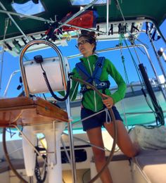 a woman standing on the deck of a sailboat in front of an open cockpit