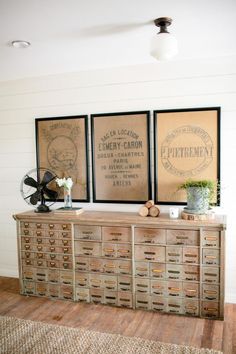 an old dresser with drawers and two pictures on the wall above it, along with other items