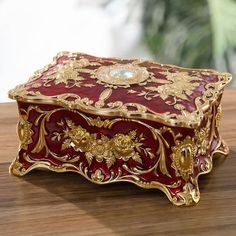 a red and gold box sitting on top of a wooden table